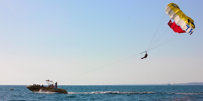 Enjoy parasailing in Dubai over a stylish beachfront with vibrant murals and cafes.