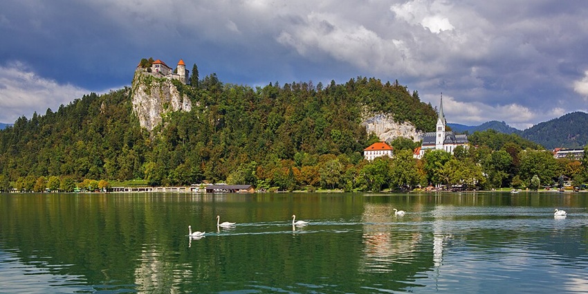 Valentine’s Day in Slovenia at the glacial lake, featuring an island church, castle, and breathtaking alpine scenery.