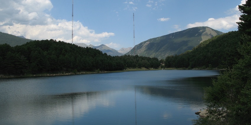 An image of a tranquil mountain lake surrounded by scenic hiking trails and lush forests.