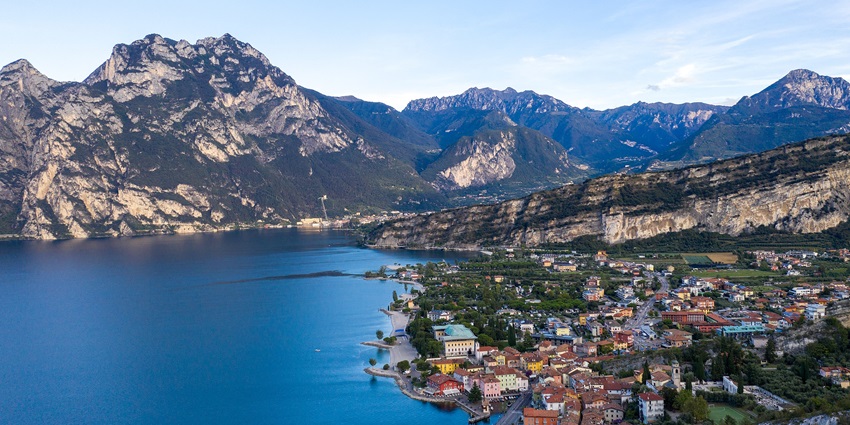 Picturesque view of Lake Garda surrounded by beautiful mountains and a small town nearby