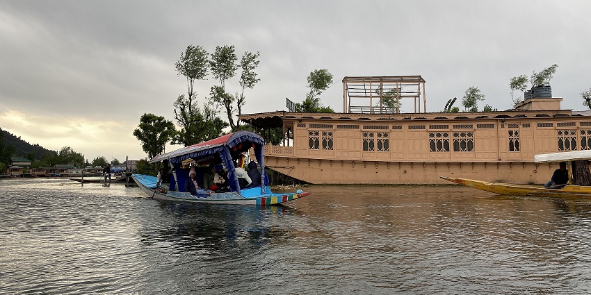 One of the best houseboats in Nigeen Lake with multiple windows and surrounding greenery.