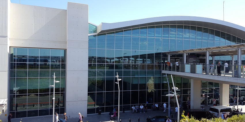 Exterior of Larnaca International Airport with aeroplanes and passenger activity, among airports in Cyprus.