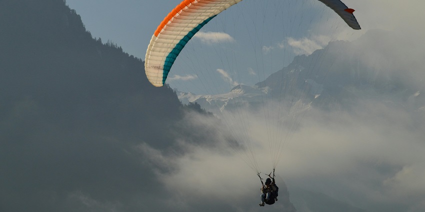 A breathtaking skydiving in Europe scene featuring a red parachute, blue sky, and clouds