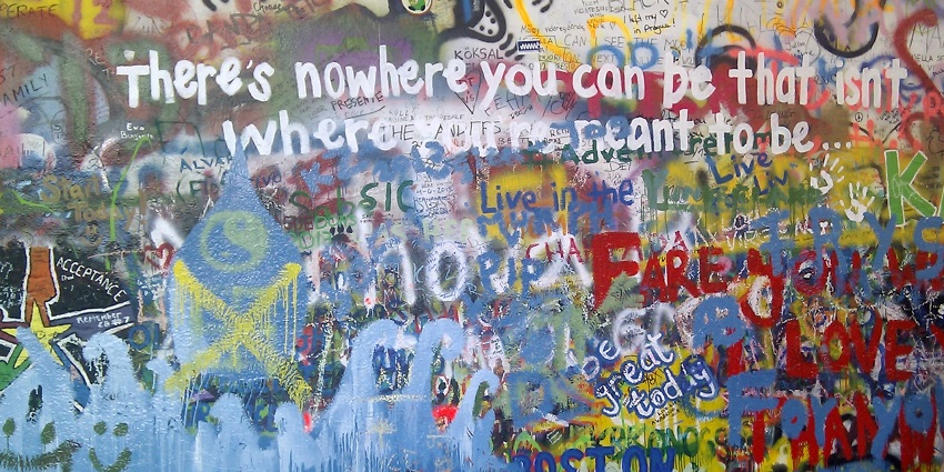 The John Lennon Wall is covered in colourful graffiti, spreading messages of peace
