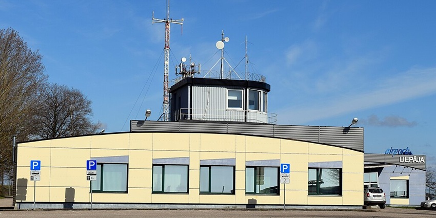 Liepāja Airport's control tower and terminal building are standing under a clear blue sky
