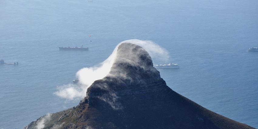 Lion’s Head mountain peak shrouded in dynamic cloud formations, surrounded by ships.
