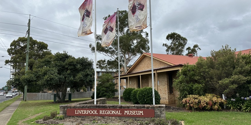Liverpool regional museum with a signboard and three flags hosted in front of a building
