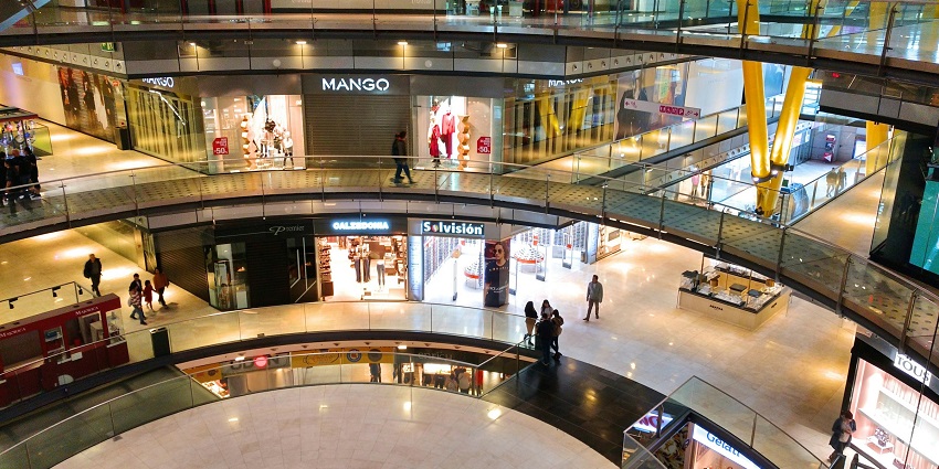 An inside view of a mall with stores selling home decor, fashion, and dining options.