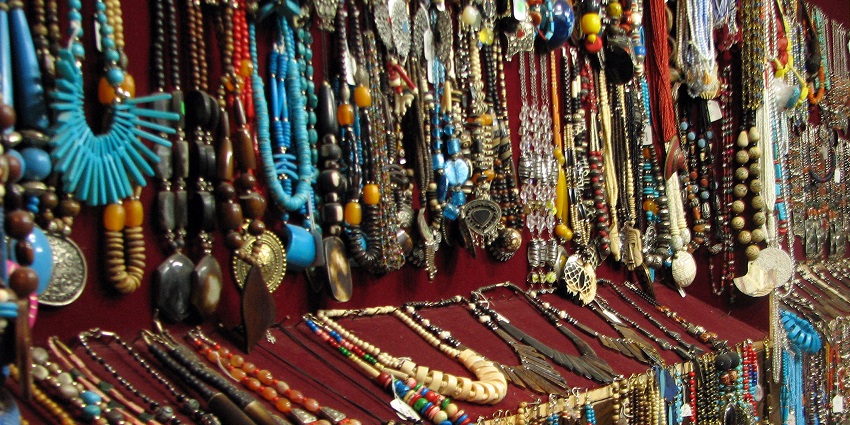 Handmade beaded necklaces and jewellery displayed on a market stall with vibrant designs.