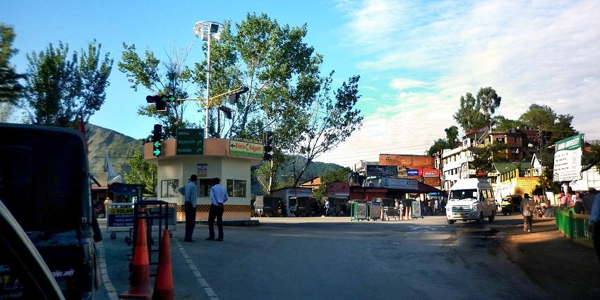 Traffic police standing on the street in Solan with traffic lights, barricades and vehicles