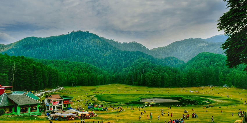 Khajjiar Lake bustling with visitors, surrounded by mountains, camps, and deodar trees