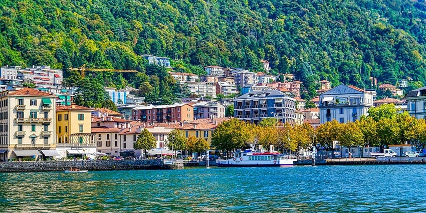 Scenic view of Lake Como with a hillside town and colorful houses overlooking the water.
