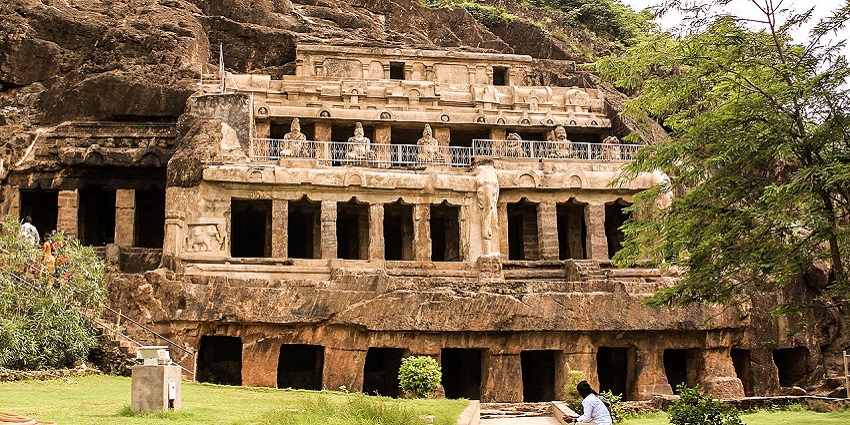 Tourists sit near Undavalli Caves, which are carved out of Sandstone rocks in Andhra Pradesh.