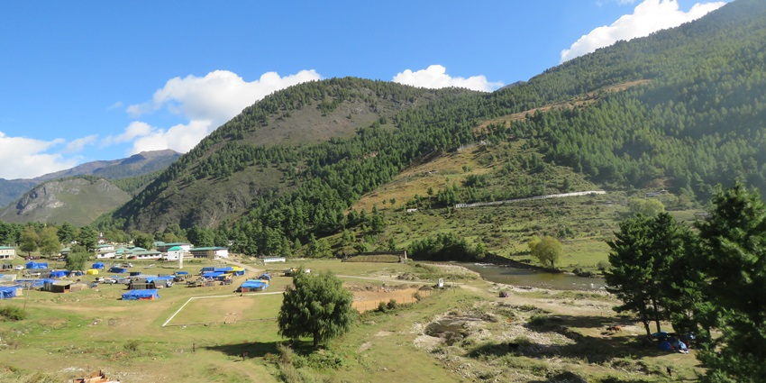 An image showing a view of Haa Valley with traditional Bhutanese houses and vast greenery.