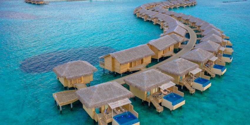 Kuramathi Island with coral reefs, seaplane access, and stunning turquoise waters.