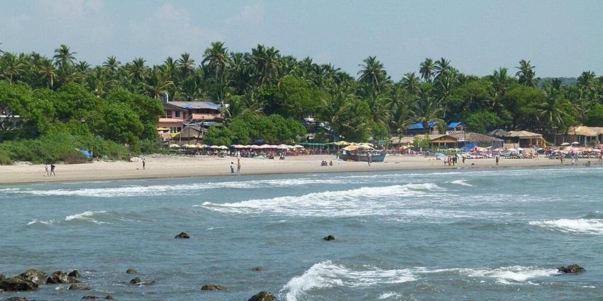 Arambol Beach's rocky side view in Goa, with waves crashing against the rugged shoreline
