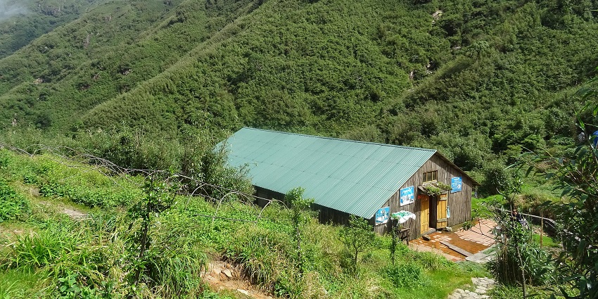 An image of Fansipan Mountain in Vietnam, covered by cloudy mist and dense green forest