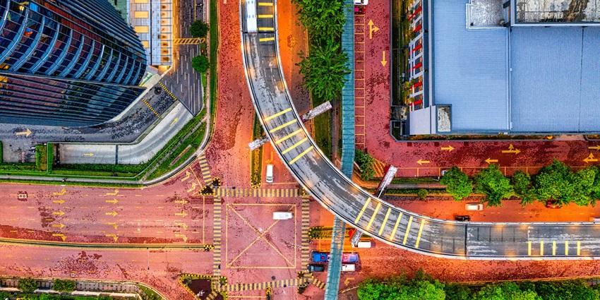 An image of Petaling Jaya featuring a curved road, glass building, pedestrian crossings