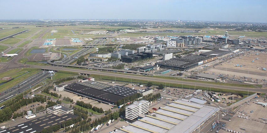 Schiphol airport from above with runways, terminal buildings and aeroplanes parked
