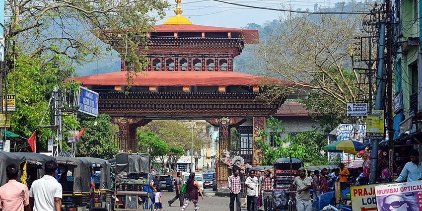 Image of the Bhutan gate surrounded by vehicles and people walking around