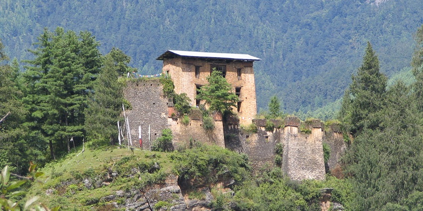 Image of a remaining ruin of the fort of Drukgyel Dzong, surrounded by lush greenery