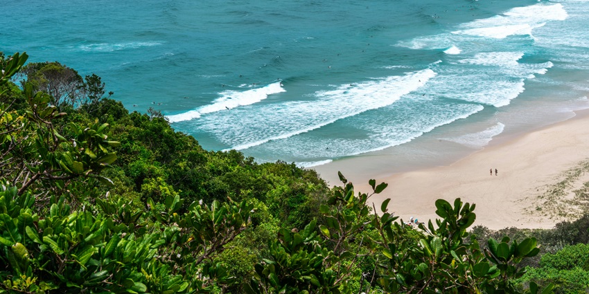 Majestic view of the turquoise waves crashing the golden shores of Byron Bay