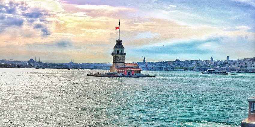 A scenic view of Maiden's Tower with the Istanbul skyline in the background.