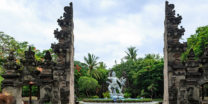Handara Gate in Bali, Indonesia, with misty mountains and greenery surrounding it.
