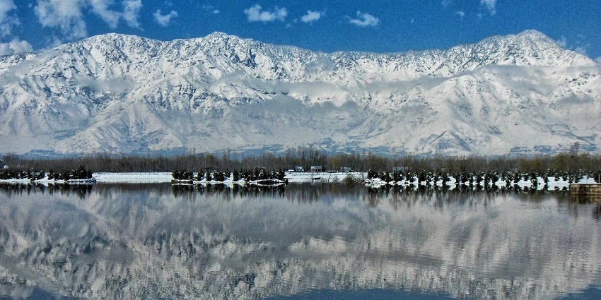 A picture of Dal Lake in December in Srinagar, surrounded by snow-covered landscapes in winter