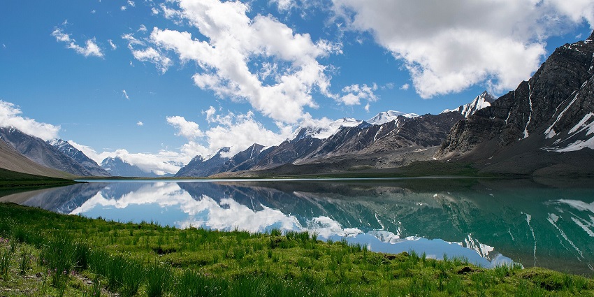 View of the deepest lake in Pakistan, the Karambar lake with reflections of the snowy mountains