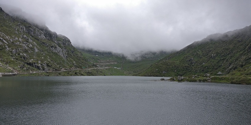 Changu lake with a still water body surrounded by green mountains
