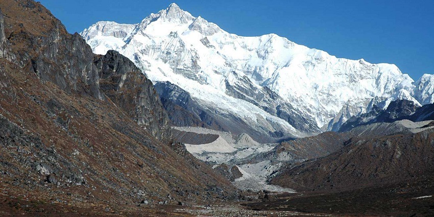 View of Mount Kanchenjunga peak covered in snow with sandy and rocky mountains
