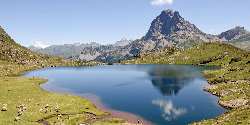 A panoramic view similar to Wular Lake with mountains around the tranquil waters.
