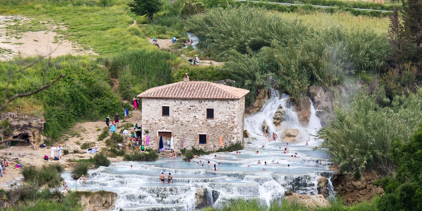Clean waters of Saturnia Hot Springs flowing over natural limestone terraces.