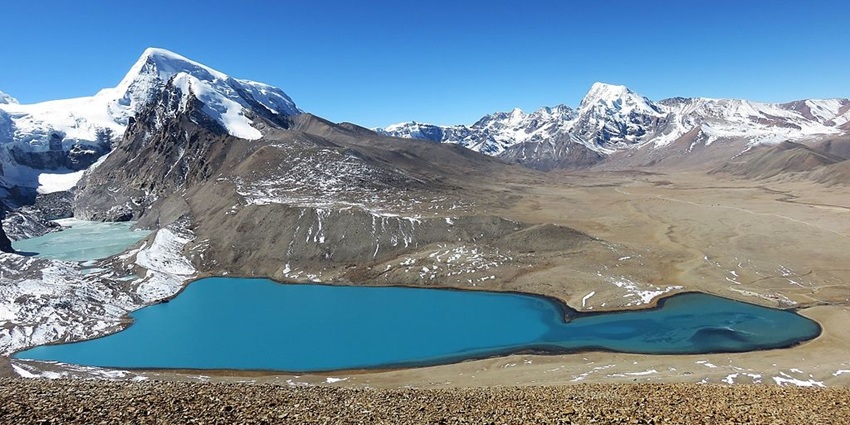 Gurudongmar lake in october from the top, surrounded by sandy shorelines and mountains
