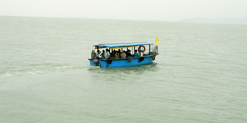 A traditional boat glides across the vast expanse of Chilika Lake, the largest brackish water lake in India.