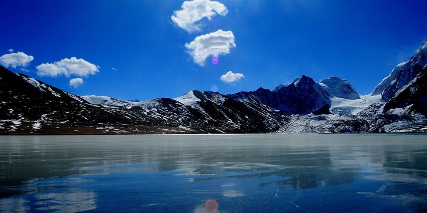Sunshine shows visible cracks of freshly frozen Gurudongmar Lake in Northern Sikkim, India