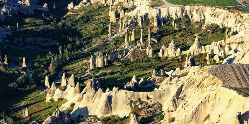 A picturesque view of Love Valley with its towering fairy chimneys and lush greenery.