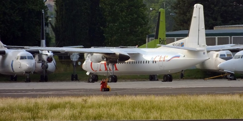 Luena Airport with multiple aeroplanes parked near the runways, green grass and buildings.