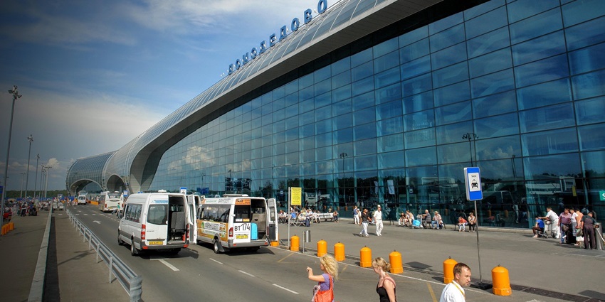 Cars parked and passengers wait outside the Lukulu airport terminus, an airport in Zambia, covered with shiny glass sheets