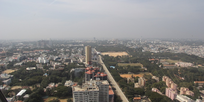 An aerial view of the MG Road decked with towering buildings and bustling markets.