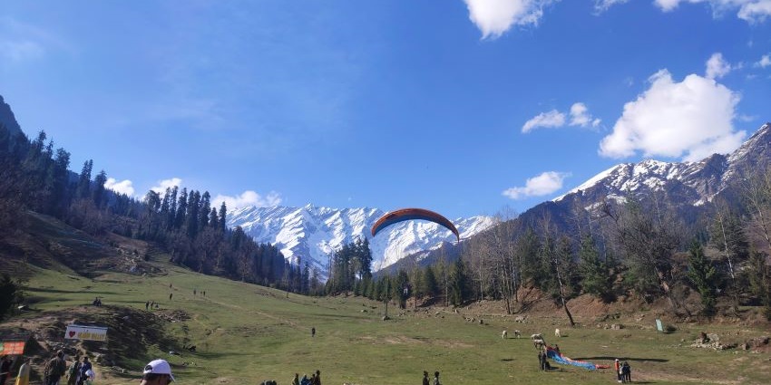 An image of people paragliding, and engaging in winter activities in Solang Valley.