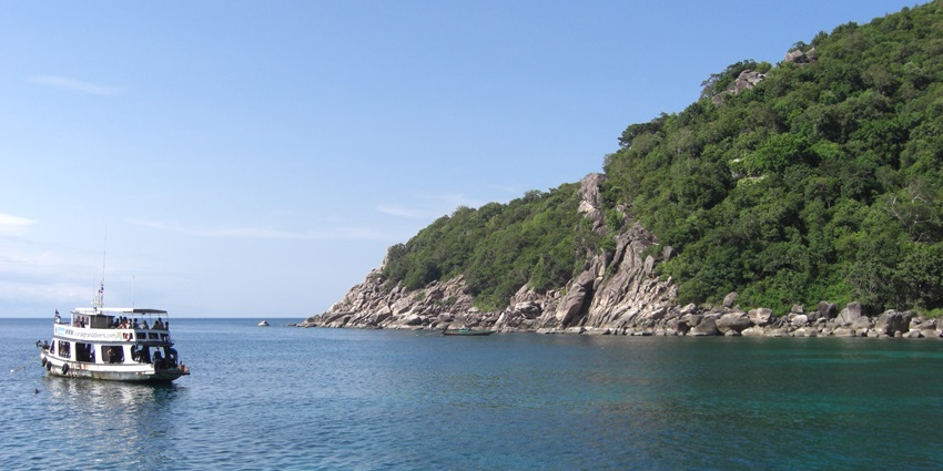 A breathtaking view of Mango Bay featuring a giant ship sailing on the azure waters.