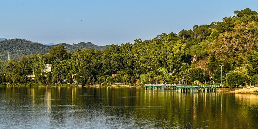 An image of Mansar Lake with serene waters and lush greenery, showcasing a beautiful lake in Jammu.