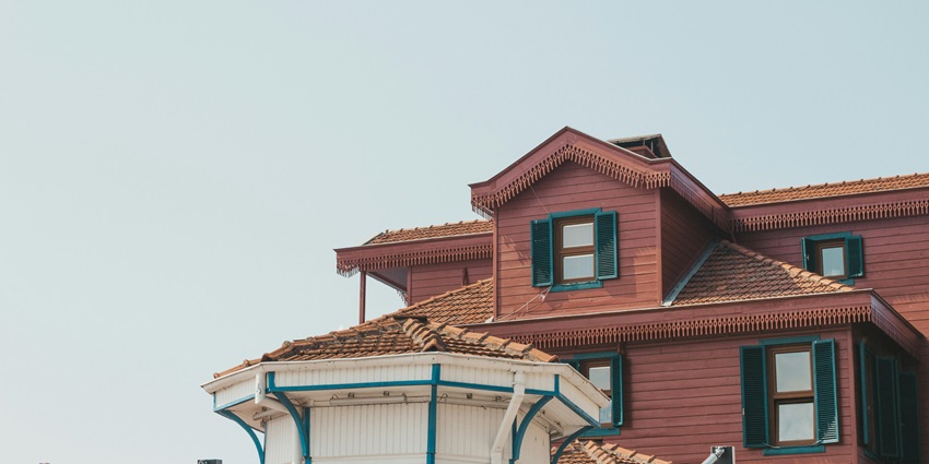 Visit this quaint brown wooden house with sloping roof nestled in greenery, offering a rustic and peaceful setting, one of the best things to do in Pekanbaru.