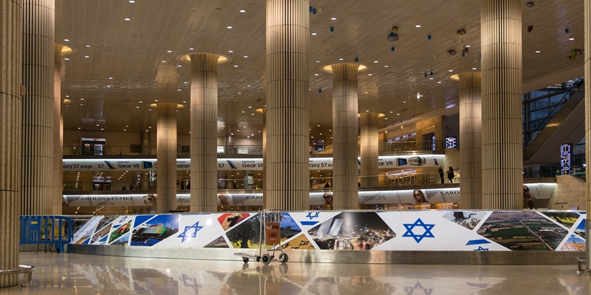 An international airport terminal with modern architecture, lights and a clear backdrop.
