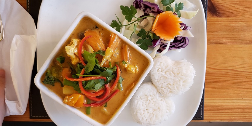 An Image of rich and aromatic Thai curry with tender meat, potatoes, and peanuts.