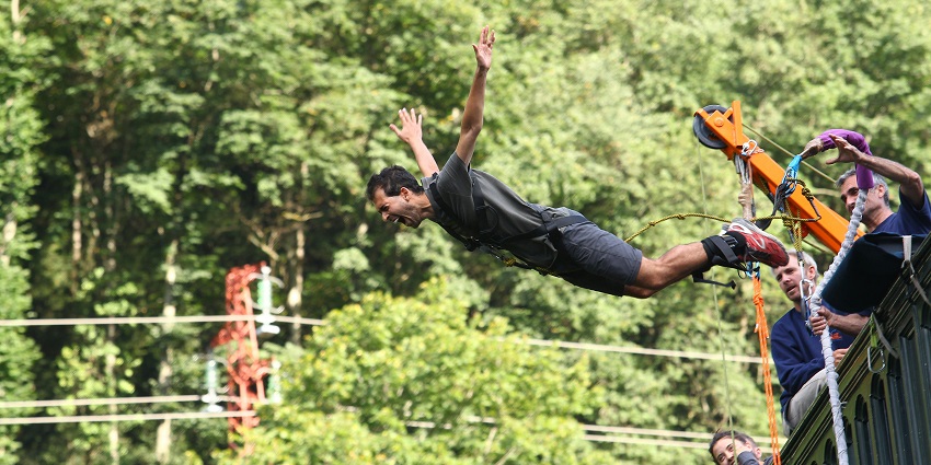 A person during bunjee jumping in South Goa, free-falling with arms outstretched.