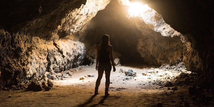 An image showing people exploring a cave with winding passages, similar to Me Cung Cave.