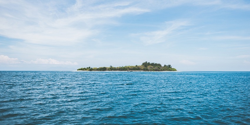 A breathtaking vista of Meedhoo Island surrounded by azure waters and lush greenery.